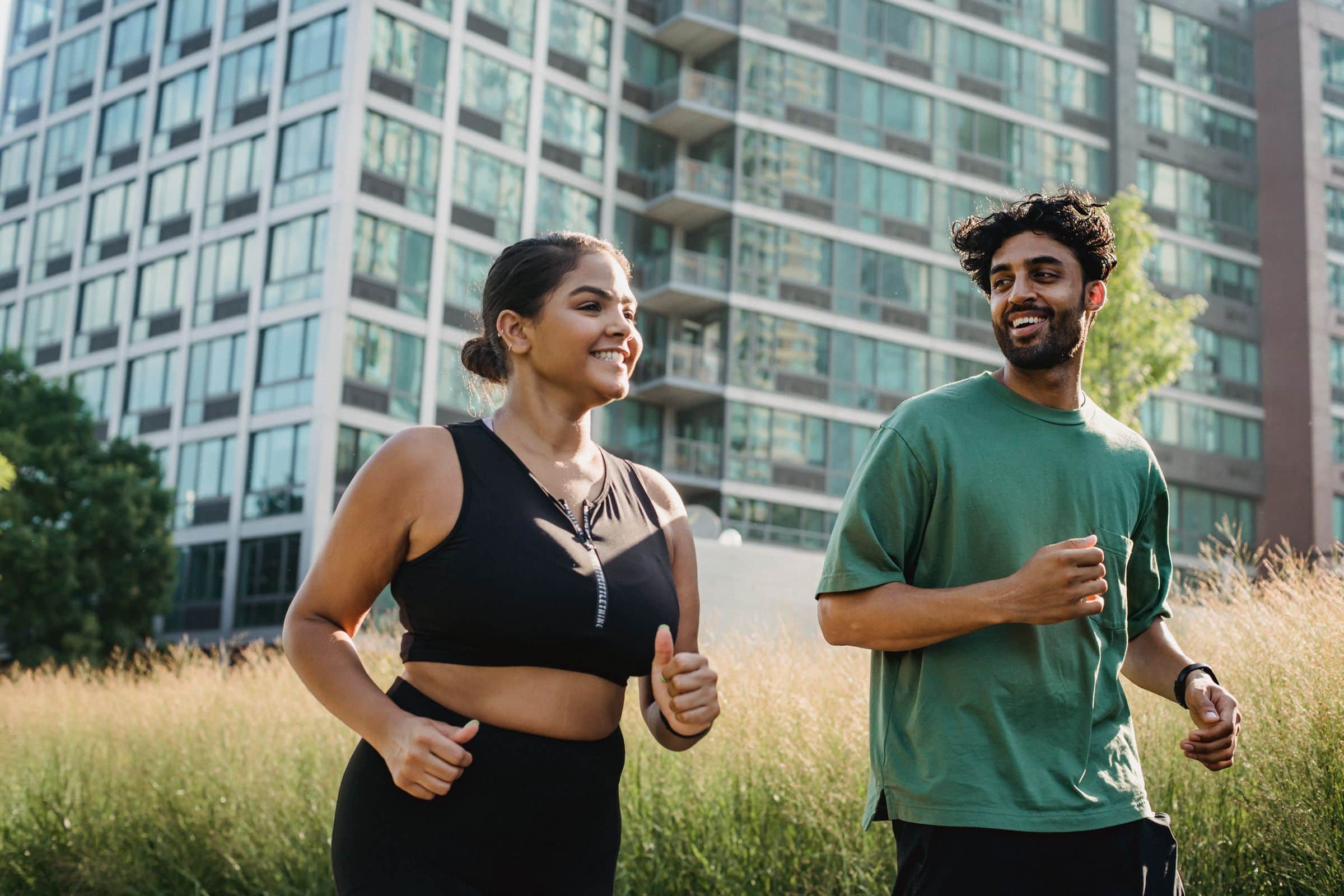 Two people running together on a city path, smiling